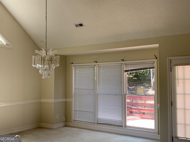 unfurnished dining area with a chandelier, lofted ceiling, a textured ceiling, and baseboards