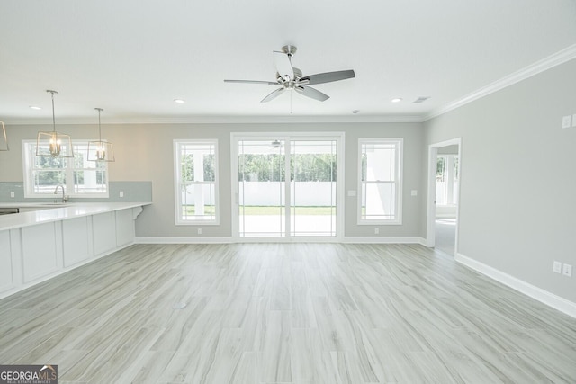 137 Amanda Trce, Kingsland, GA 31548 - unfurnished living room featuring a sink, a ceiling fan, baseboards, light wood-type flooring, and ornamental molding