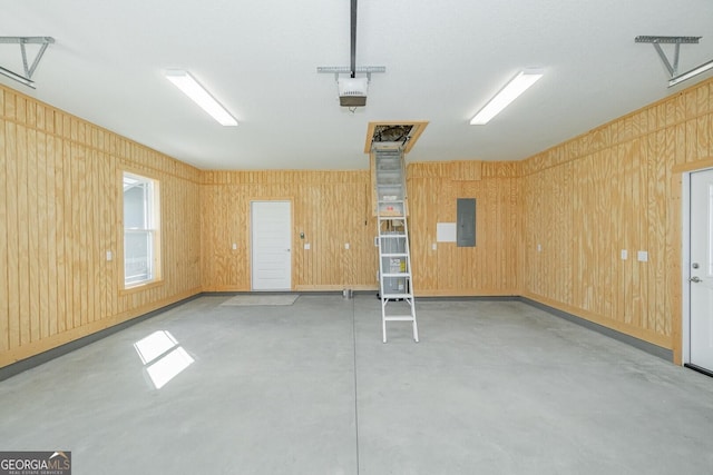 137 Amanda Trce, Kingsland, GA 31548 - garage featuring electric panel, a garage door opener, and wood walls