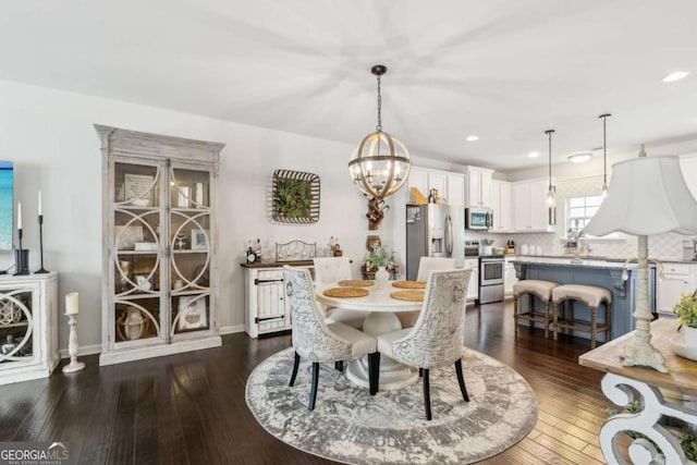 dining area with dark wood-style flooring, recessed lighting, a chandelier, and baseboards