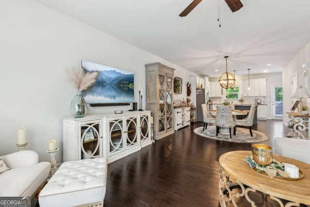 living room with dark wood finished floors, a ceiling fan, recessed lighting, and a chandelier