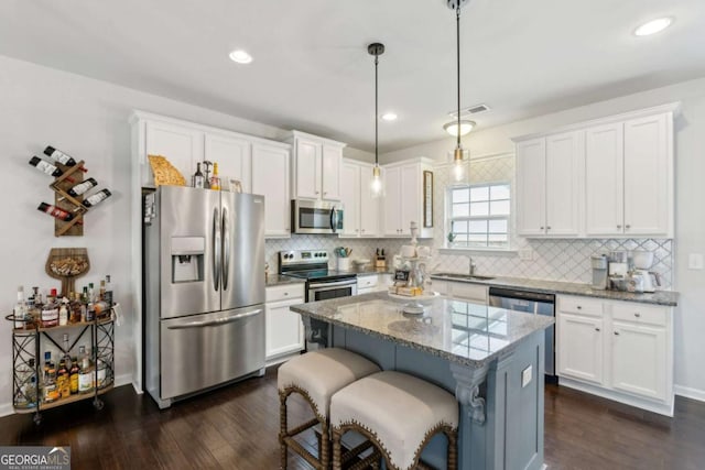 kitchen with appliances with stainless steel finishes, white cabinetry, dark wood finished floors, and recessed lighting