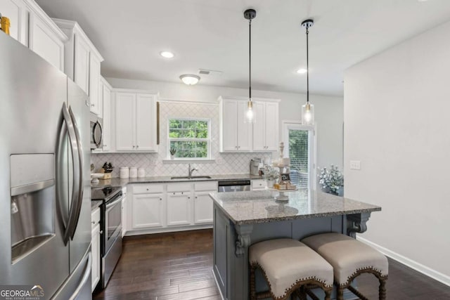 kitchen with stainless steel appliances, a sink, backsplash, white cabinets, and recessed lighting