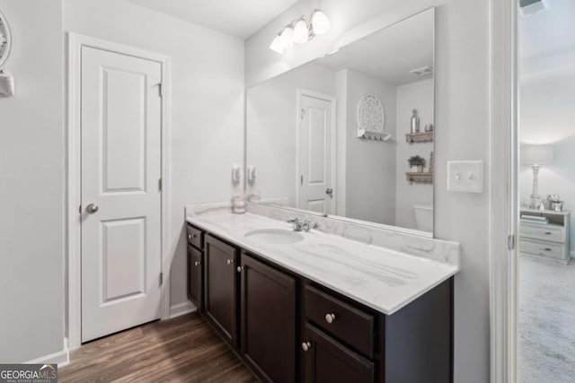 bathroom with vanity, wood finished floors, and baseboards