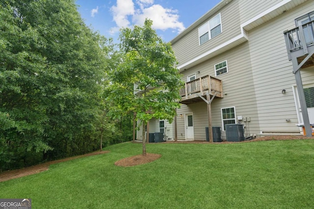 back of property featuring a lawn, central AC, and a balcony
