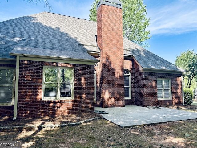 6605 New Ridge Ct, Cumming, GA 30041 - back of property with a chimney, a patio, and brick siding