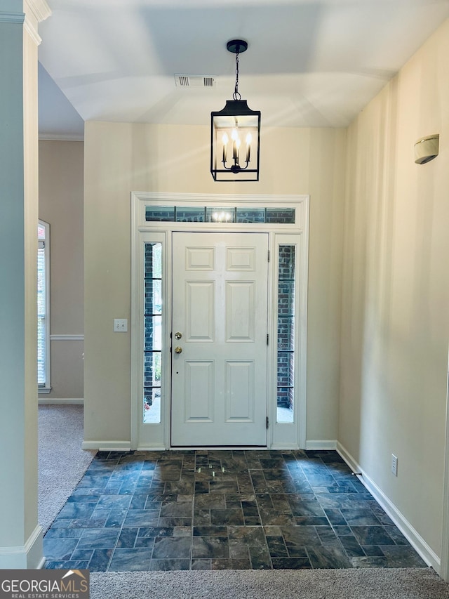 6605 New Ridge Ct, Cumming, GA 30041 - foyer featuring stone finish floors, a chandelier, and baseboards
