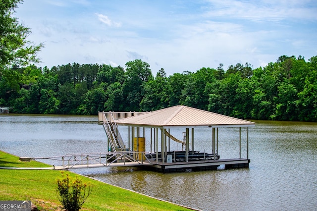 dock with boat lift, a water view, and a view of trees