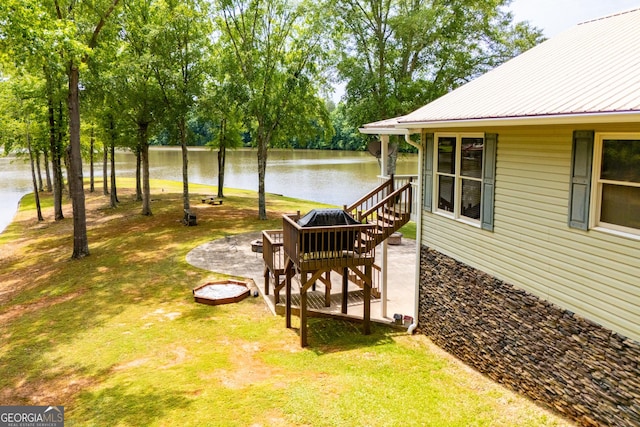 view of green lawn with a water view