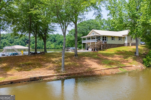 view of yard with a water view, stairs, and dirt driveway
