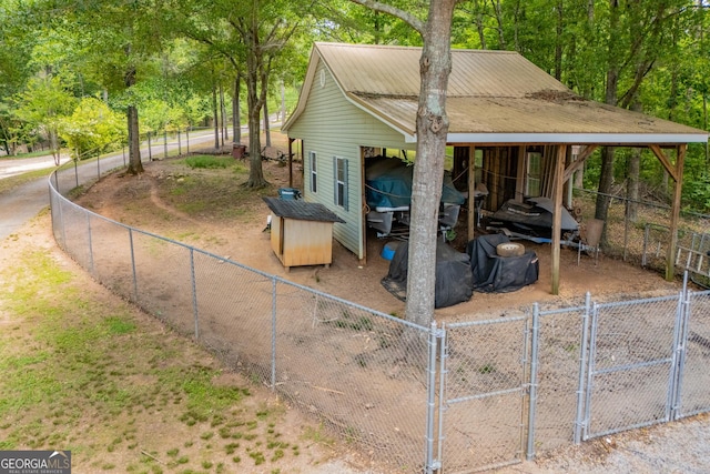 view of side of property with a gate, an outdoor structure, and a fenced backyard