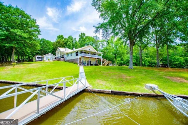 dock area featuring a water view, a yard, stairs, and view of wooded area