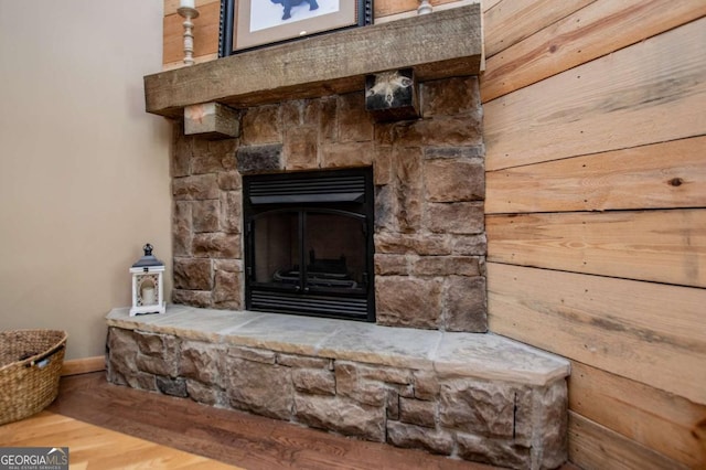detailed view of baseboards, wood finished floors, and a fireplace