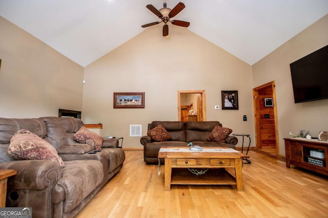 living area with ceiling fan, high vaulted ceiling, baseboards, and light wood-style floors
