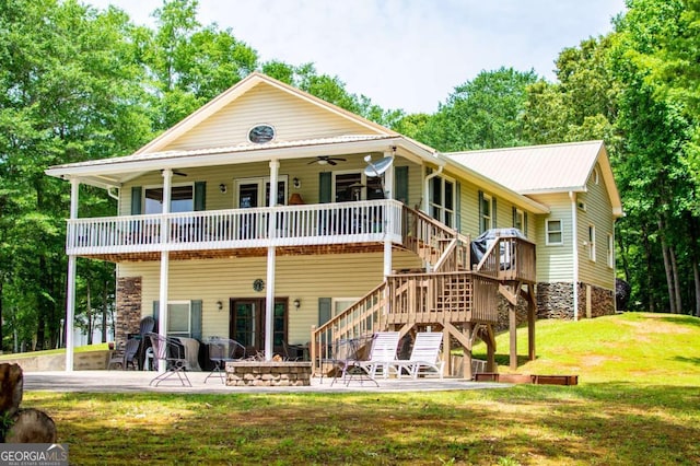 rear view of property featuring ceiling fan, a yard, a patio, stairs, and an outdoor fire pit