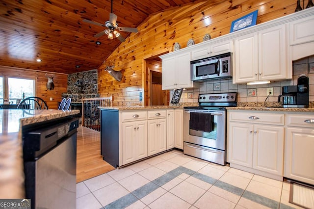 kitchen featuring appliances with stainless steel finishes, wooden walls, vaulted ceiling, wood ceiling, and light tile patterned floors