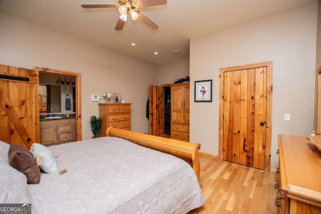 bedroom featuring light wood-style floors, a sink, recessed lighting, and baseboards