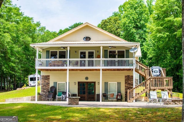 back of house featuring an outdoor fire pit, a ceiling fan, a yard, a patio, and stairs