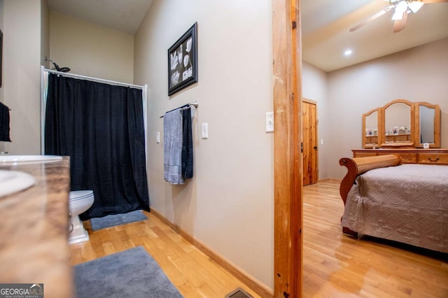 bedroom with wood finished floors, ceiling fan, and baseboards