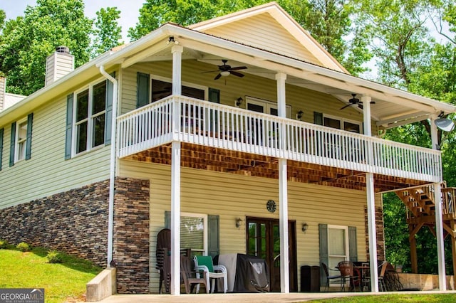 view of front of house featuring a ceiling fan, a chimney, a patio area, and a wooden deck