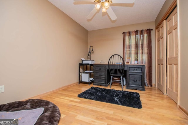 office area featuring wood finished floors, ceiling fan, and baseboards