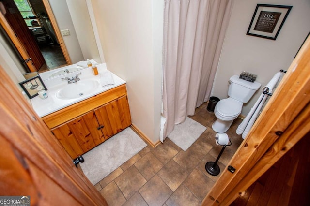 bathroom with toilet, a shower with shower curtain, and vanity