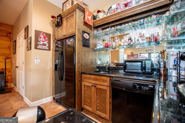 indoor bar featuring black appliances and baseboards