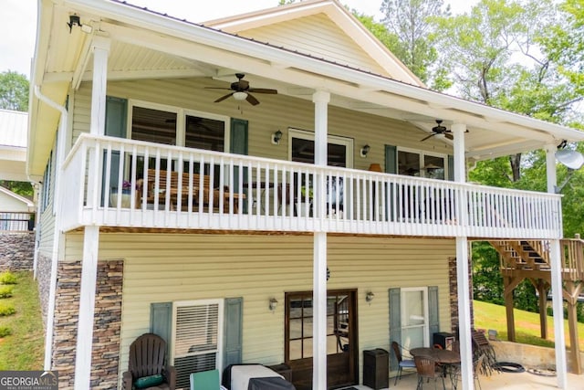 back of property featuring ceiling fan, a patio, and stone siding