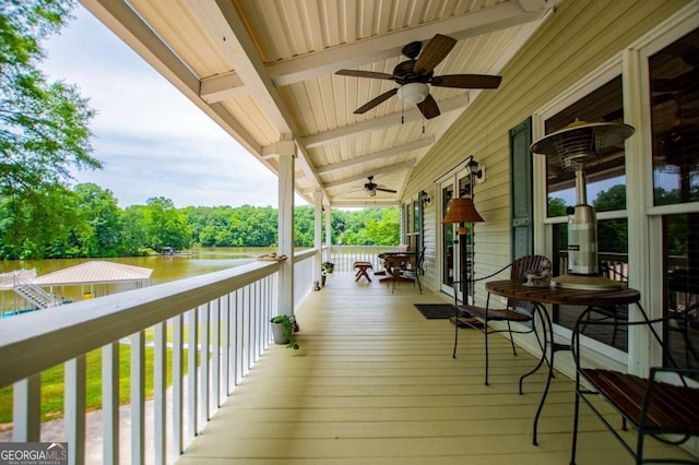 wooden porch with a water view and a ceiling fan