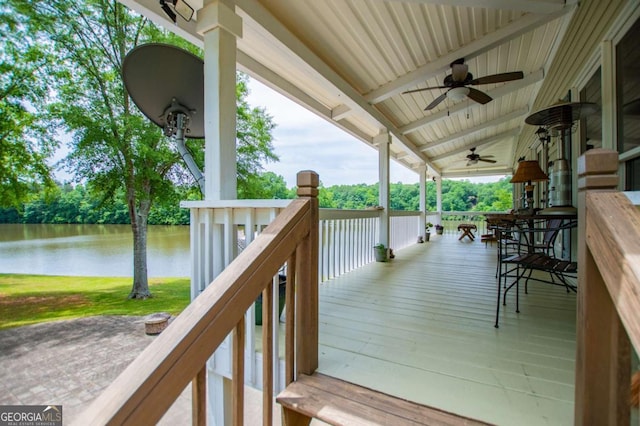 deck with ceiling fan and a water view