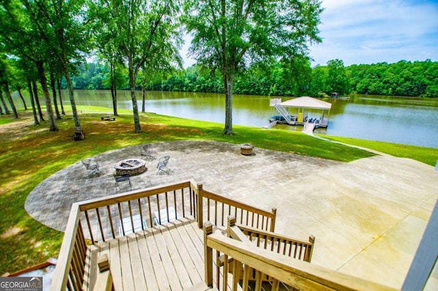 view of patio featuring a fire pit, a water view, and a dock