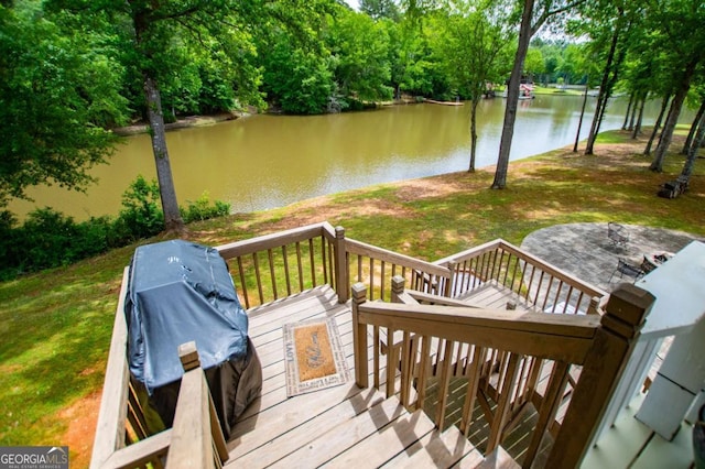 deck with a water view and a yard