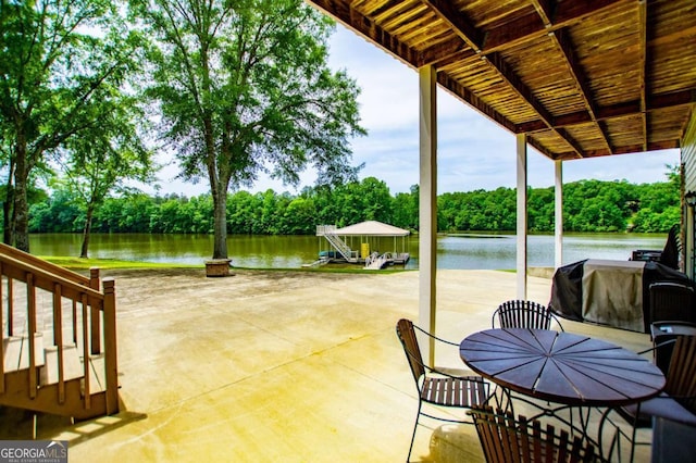 view of patio / terrace featuring a water view and view of wooded area