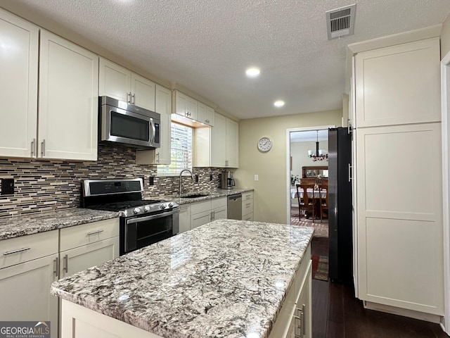 6940 Treeline Dr, Cumming, GA 30028 - kitchen with appliances with stainless steel finishes, recessed lighting, a sink, dark wood-style flooring, and white cabinetry