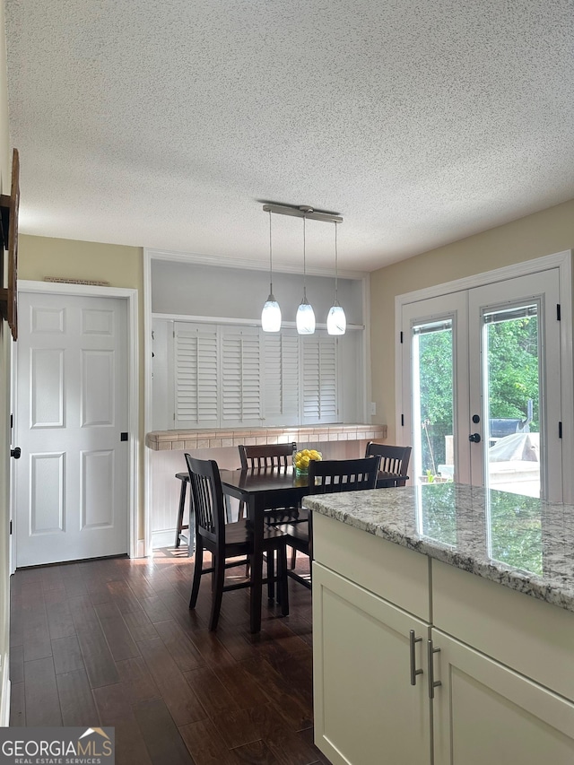 6940 Treeline Dr, Cumming, GA 30028 - dining area featuring dark wood finished floors, a textured ceiling, and french doors
