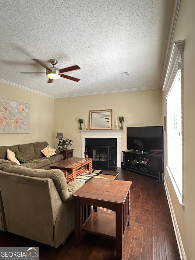 6940 Treeline Dr, Cumming, GA 30028 - living area with dark wood-type flooring, a fireplace with flush hearth, ceiling fan, a textured ceiling, and ornamental molding