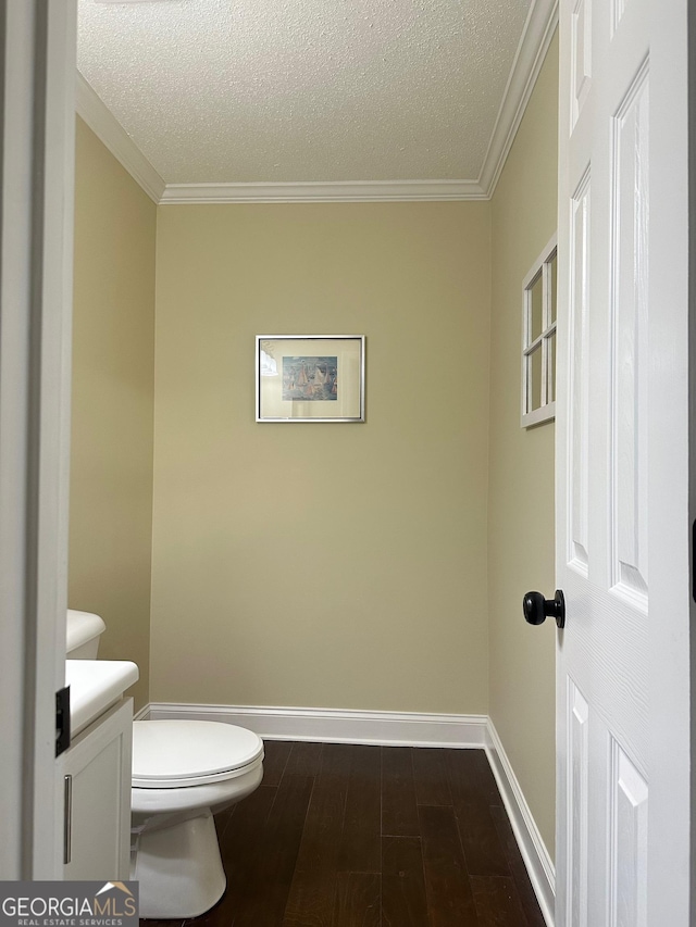 6940 Treeline Dr, Cumming, GA 30028 - half bath with baseboards, toilet, a textured ceiling, ornamental molding, and wood finished floors