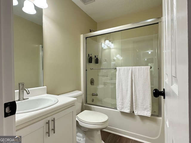 6940 Treeline Dr, Cumming, GA 30028 - full bathroom featuring vanity, shower / bath combination with glass door, wood finished floors, toilet, and a textured ceiling