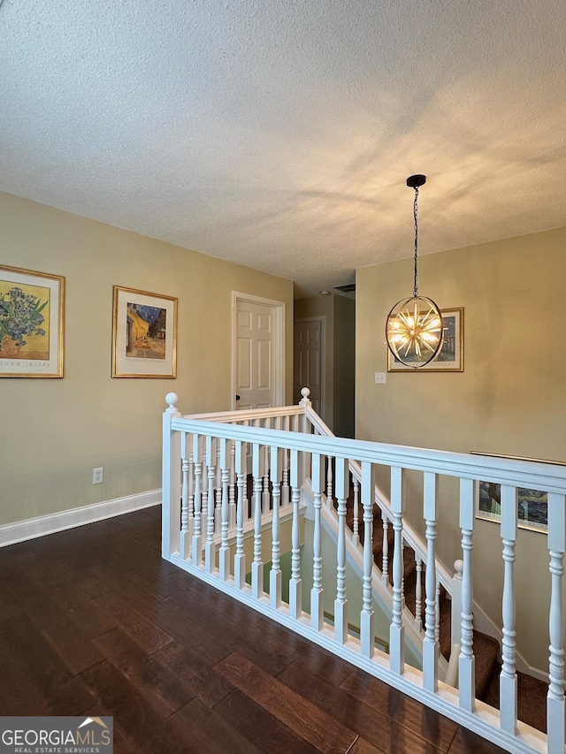 6940 Treeline Dr, Cumming, GA 30028 - stairs featuring a chandelier, wood-type flooring, a textured ceiling, and baseboards