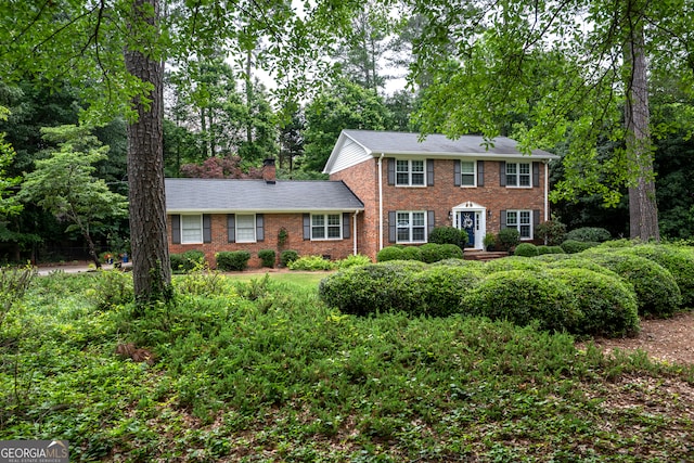 colonial house with brick siding and a chimney