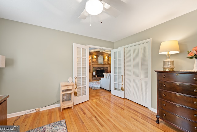 bedroom with french doors, light wood-style flooring, a closet, baseboards, and a ceiling fan