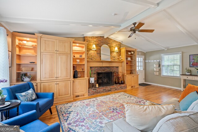 living room featuring light wood-style floors, a ceiling fan, a brick fireplace, baseboards, and built in features
