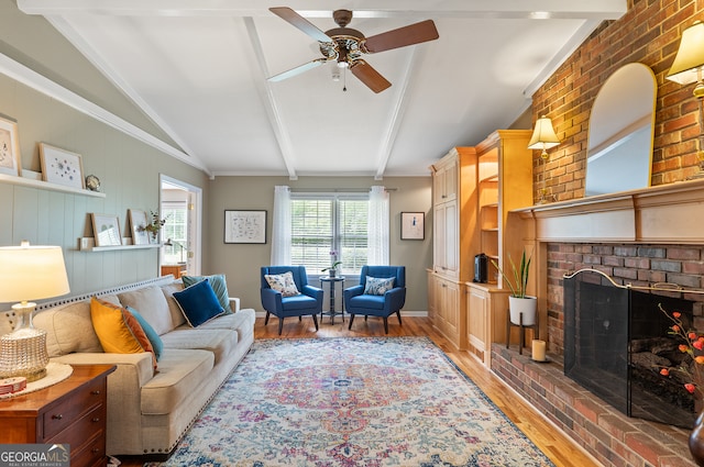 living room with light wood finished floors, ceiling fan, a brick fireplace, and baseboards