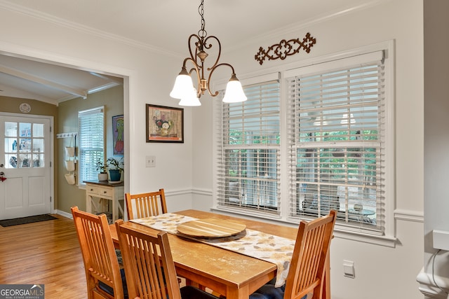 dining space with a chandelier, ornamental molding, light wood-style floors, beam ceiling, and baseboards