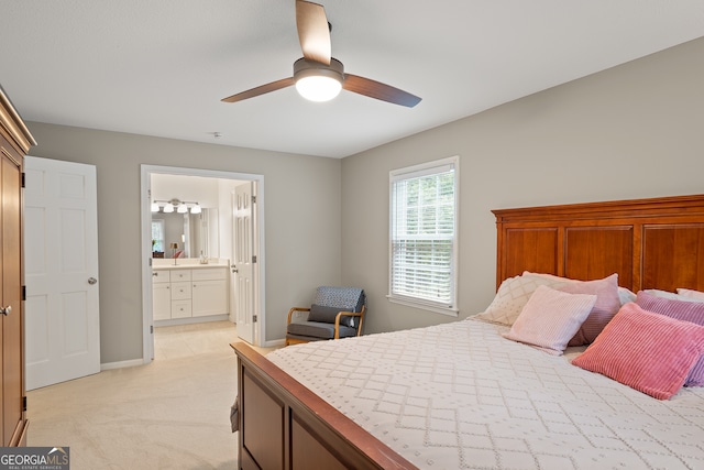 bedroom with light carpet, ensuite bathroom, a ceiling fan, and baseboards