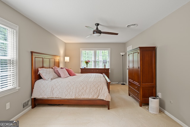 bedroom with light colored carpet, baseboards, and ceiling fan