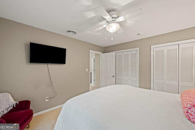 bedroom with carpet floors, two closets, baseboards, and ceiling fan