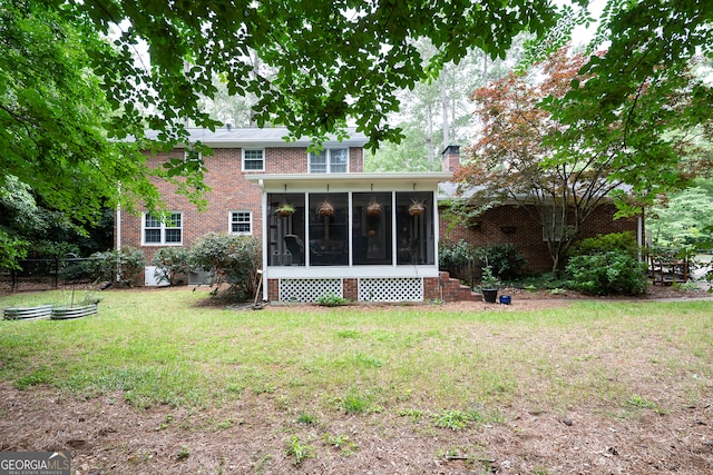 rear view of house with a sunroom, brick siding, and a chimney