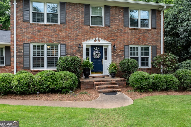 view of front of home featuring a front yard and brick siding