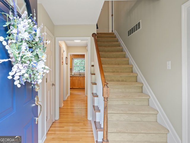 staircase with wood finished floors and baseboards